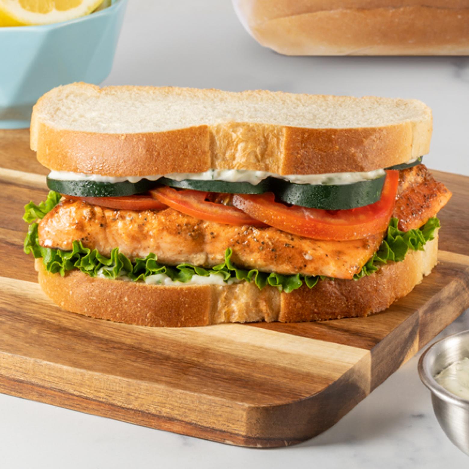 Grilled salmon sandwich with herb mayo, cucumbers, tomatoes and lettuce